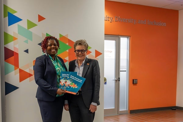 Dr. Joy Walcott-Francis, Director, Equity, Diversity, and Inclusion (L) and Dr. Paula Burns, President and CEO, hold a copy of the Langara College EDI framework document.