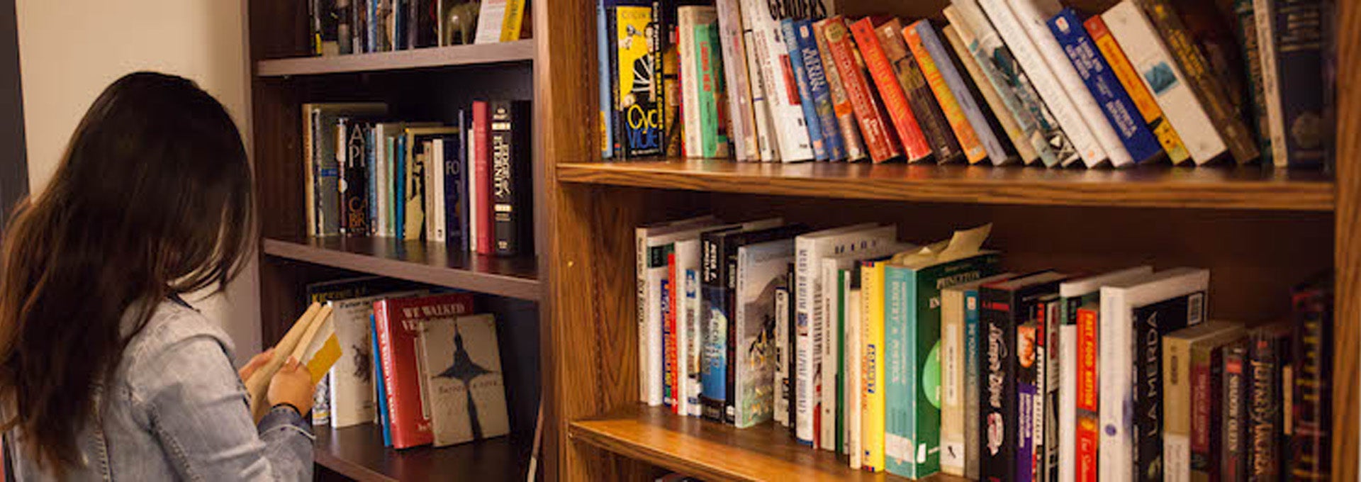 a woman looking at books on a shelf