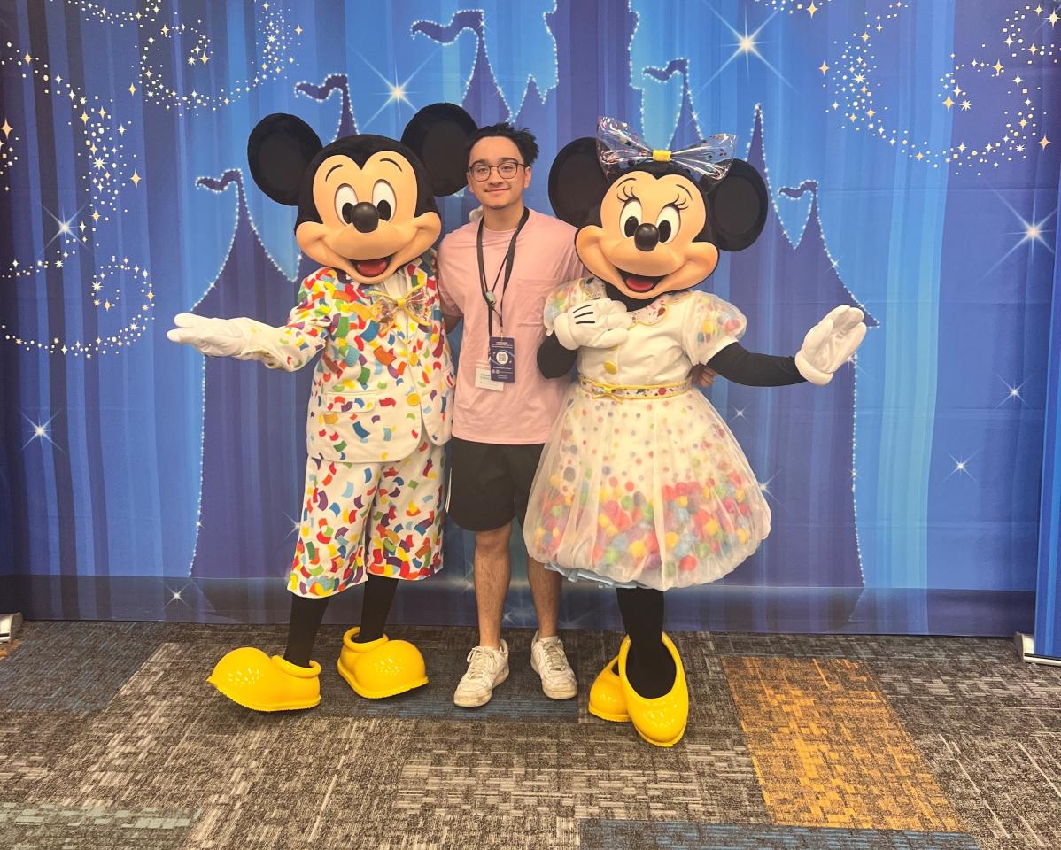 Paco Rodrigo poses with Mickey and Minnie Mouse.